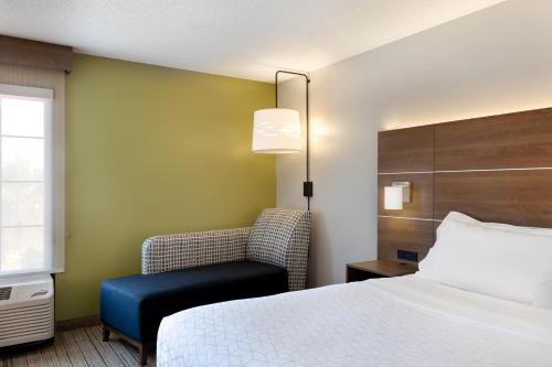 a hotel room with a bed and a chair at Holiday Inn Express & Suites Milton East I-10 by IHG in Milton