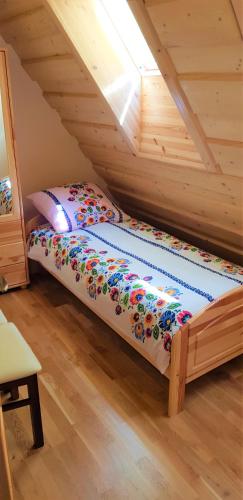 a bed in the attic of a wooden house at Domek Agroturystyczny na Putówce in Słopnice