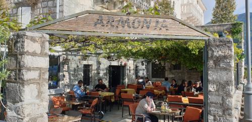 a group of people sitting at an outdoor restaurant at Apartmani Armonia in Perast