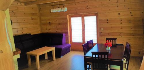 a living room with a table and a purple couch at Domek Agroturystyczny na Putówce in Słopnice
