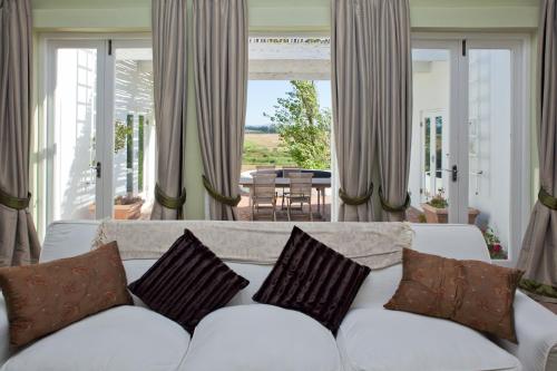 a living room with a white couch with pillows at Hawksmoor House in Stellenbosch