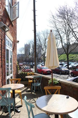 a patio with tables and chairs and an umbrella at Tower Hotel in Lincoln