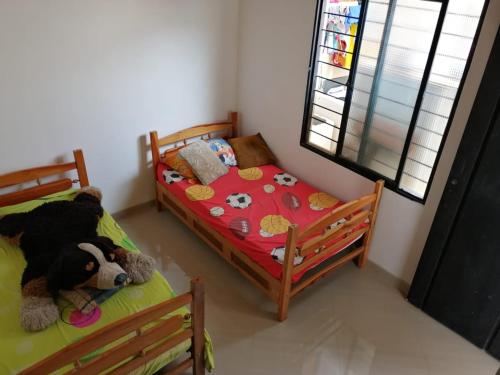 sypialnia z 2 łóżkami i misiem w obiekcie Villas de Santa Ana w mieście Guamo