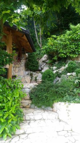 a stone walkway with a wooden shelter in a garden at Kuća za odmor Zeleni biser in Generalski Stol