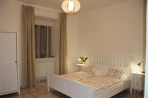 a bedroom with a white bed and a window at Dvůr Nové Zámky in Mladeč