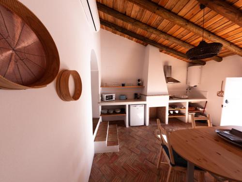 eine Küche und ein Esszimmer mit einem Holztisch in der Unterkunft Casas de Mértola in Mértola