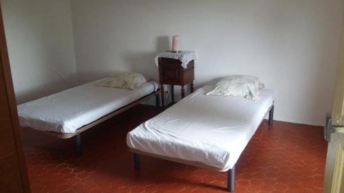 ロクブリューヌ・シュル・アルジャンにあるBastide les Buisのツインベッド2台(白いシーツ付)が備わる客室です。