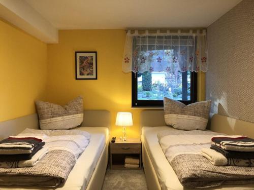 two beds in a room with a window at Ferienwohnung Baer in Hoppegarten