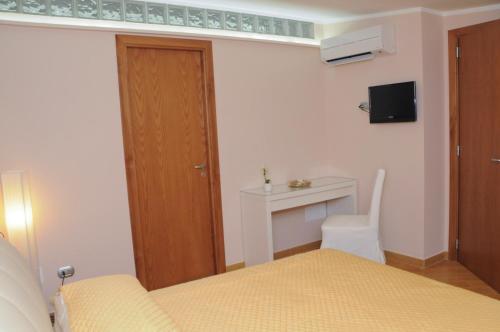 a bedroom with a bed and a desk and a door at Casa Vacanze Li Galli in Sant'Agnello