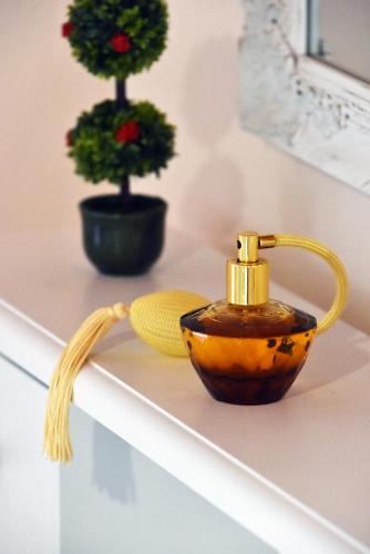 a bottle of honey and a bowl on a shelf at Karmela's Cottage by CorfuEscapes in Agios Ioannis Peristerion