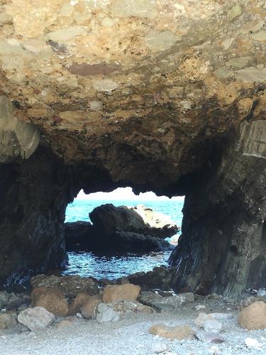 a cave on the beach with the ocean in the background at Terra Sinus Holiday House in Terrasini
