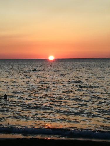 a person in a boat in the ocean at sunset at Terra Sinus Holiday House in Terrasini