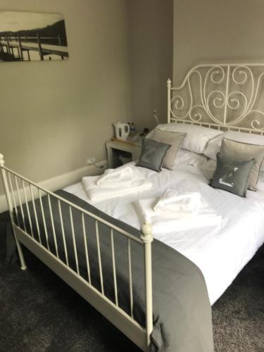 a bed with white sheets and pillows in a bedroom at Two Little Ducks Guesthouse in Ellesmere Port