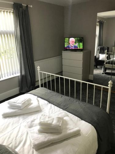 a bedroom with a bed with two white towels on it at Two Little Ducks Guesthouse in Ellesmere Port