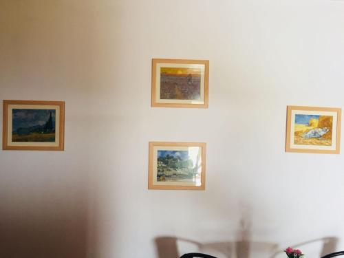 four paintings on a white wall at Khan Alsira - חאן אלסרה in Alsira