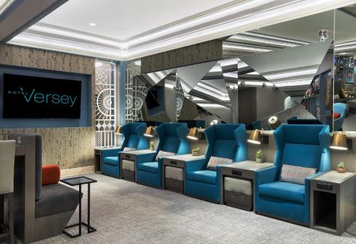 una sala d'attesa con sedie blu e TV di Hotel Versey Chicago Lincoln Park a Chicago