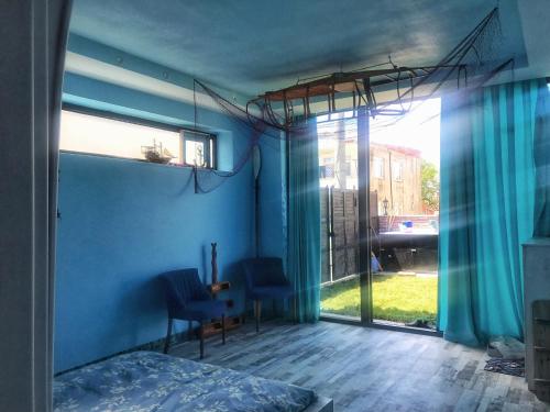 a bedroom with blue walls and a bed and a window at HemDem Alçıtepe in Canakkale