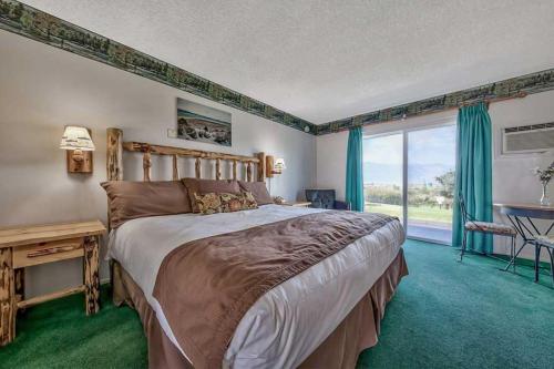 a bedroom with a large bed and a large window at Walker River Lodge in Bridgeport