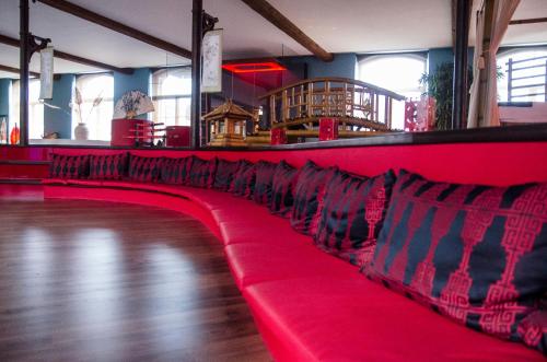 a red couch in a room with a unintention at Le Baiser de Shogun in Ensival