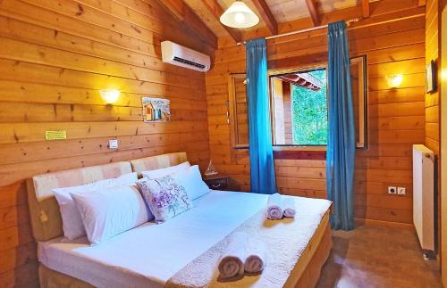 a bed in a wooden room with slippers on it at Luxury Wooden Villa with Pool, The Nest in Kato Korakiana