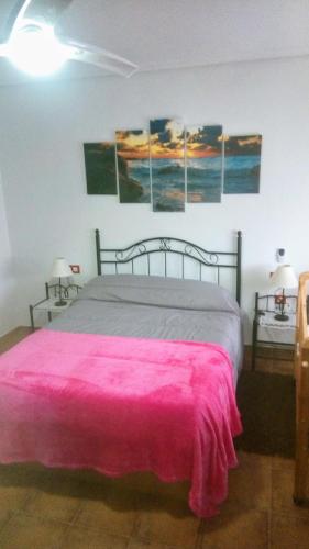 a bedroom with a bed with a pink blanket at Paraiso Huertano in Alquerías