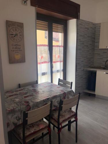 a dining room table with chairs and a clock on the wall at Piccolo fiore in Capaccio-Paestum