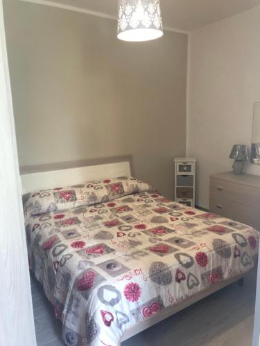 a bedroom with a bed with a floral comforter at Piccolo fiore in Capaccio-Paestum