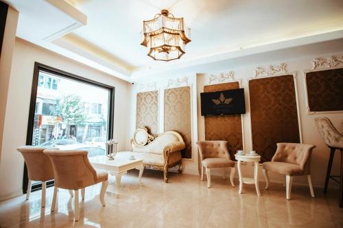 Istanroom by Keo في إسطنبول: غرفة معيشة مع كراسي وطاولة وثريا