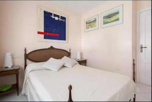 a white bedroom with a bed with white sheets at ADOSADO DE LUJO CON PISCINA PRIVADA en ZONA MUY TRANQUILA in Gandía