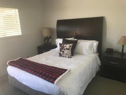 a bedroom with a large bed with a brown headboard at Country West Motel of Rock Springs in Rock Springs
