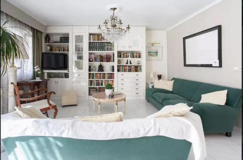 a living room with a green couch and a table at ADOSADO DE LUJO CON PISCINA PRIVADA en ZONA MUY TRANQUILA in Gandía