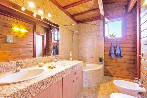 a bathroom with two sinks and a tub at Luxury Wooden Villa with Pool, The Nest in Kato Korakiana