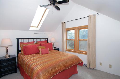 a bedroom with a bed with red pillows and a window at Cozy Lake Michigan Cottage on Lake Michigan-Pet Friendly! in Sheboygan