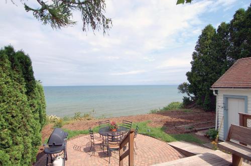 シボイガンにあるCozy Lake Michigan Cottage on Lake Michigan-Pet Friendly!の海を望むパティオ(テーブル、椅子付)