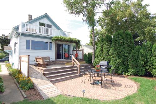 a house with a patio with a table and chairs at Cozy Lake Michigan Cottage on Lake Michigan-Pet Friendly! in Sheboygan