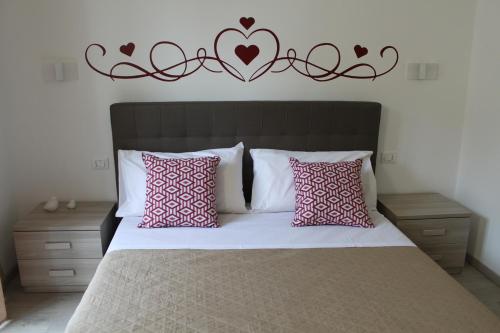 a bedroom with a large bed with hearts on the wall at Le Coccole in La Spezia