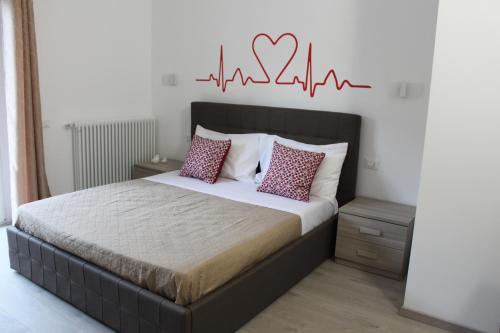 a bedroom with a bed with a heart sign on the wall at Le Coccole in La Spezia