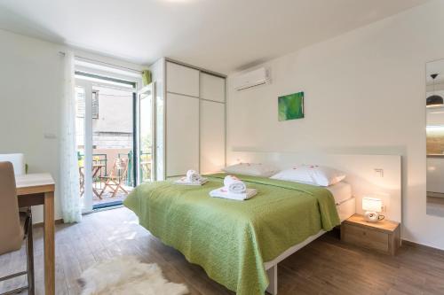 een slaapkamer met een bed met een groene deken bij Maggy & Anna Apartment in Split