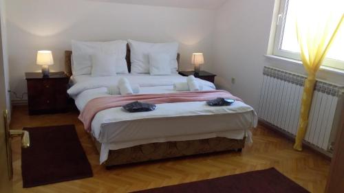 a bedroom with a large bed with two towels on it at Apartment VILLA MERCI in Sarajevo