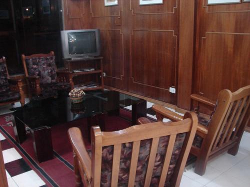 a living room with a table and chairs and a tv at Cheltum Hotel in Trelew