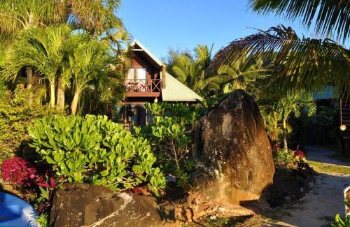a house with a balcony and a large rock at Sokala Villas in Muri