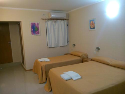 a hotel room with two beds and a window at Cheltum Hotel in Trelew