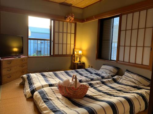 een slaapkamer met 2 bedden en een kom erop bij Koto House in Yachiyo