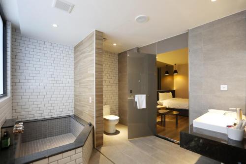y baño con ducha, lavabo y aseo. en SUNLINE Motel & Resort en Baihe