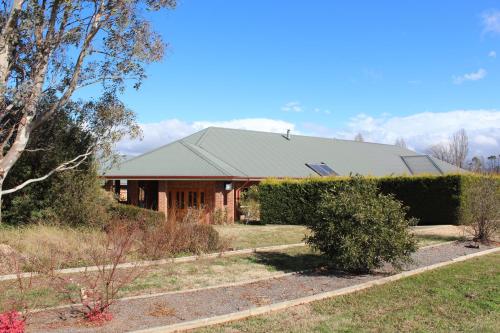 a house with a hedge in front of it at Gundaroo Manor Bed & Breakfast in Gundaroo