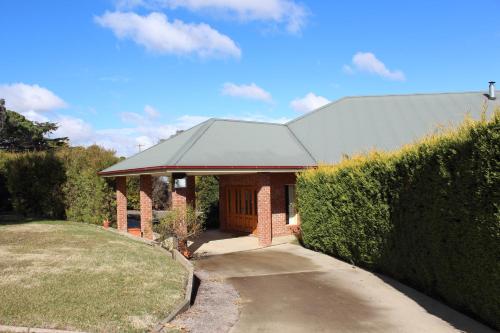 a brick building with a black roof at Gundaroo Manor Bed & Breakfast in Gundaroo