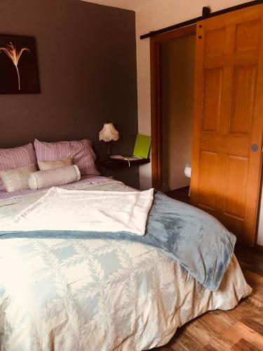 a bedroom with a bed and a open door at A Hyde Away Inn B&B in Tok