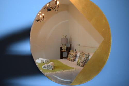 a mirror of a bedroom with a bed and towels at The Manor House at Quorn in Loughborough