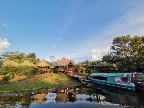 a boat parked in front of a group of houses at Grand Amazon Lodge and Tours - All Inclusive in Paraíso