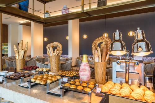 Un buffet con pan y pasteles en una mesa. en Best Western Premier Sonasea Phu Quoc, en Phu Quoc